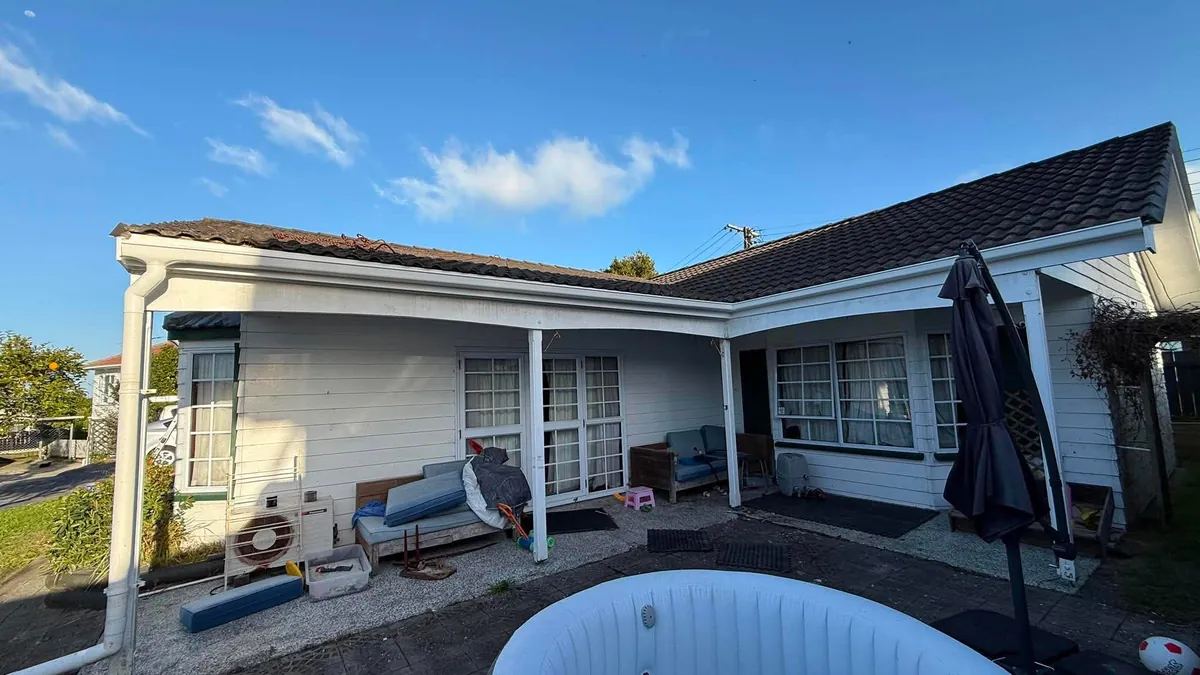 White weatherboard house under a clear blue sky, the best time to paint a house exterior