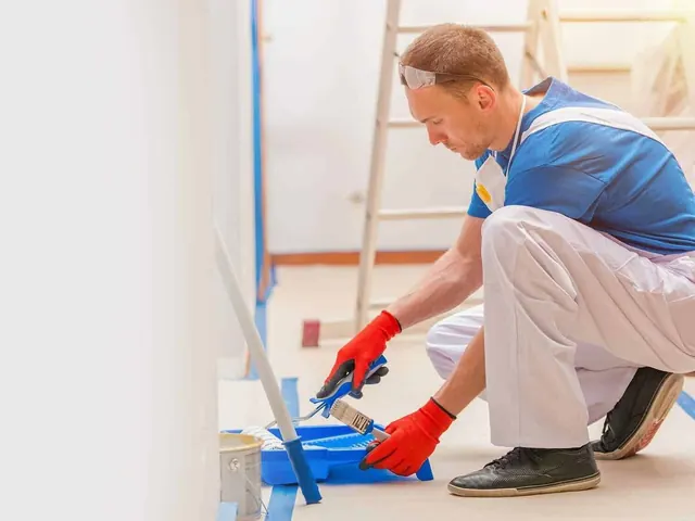 Painter applying finish coat to a wall in a newly renovated Auckland home