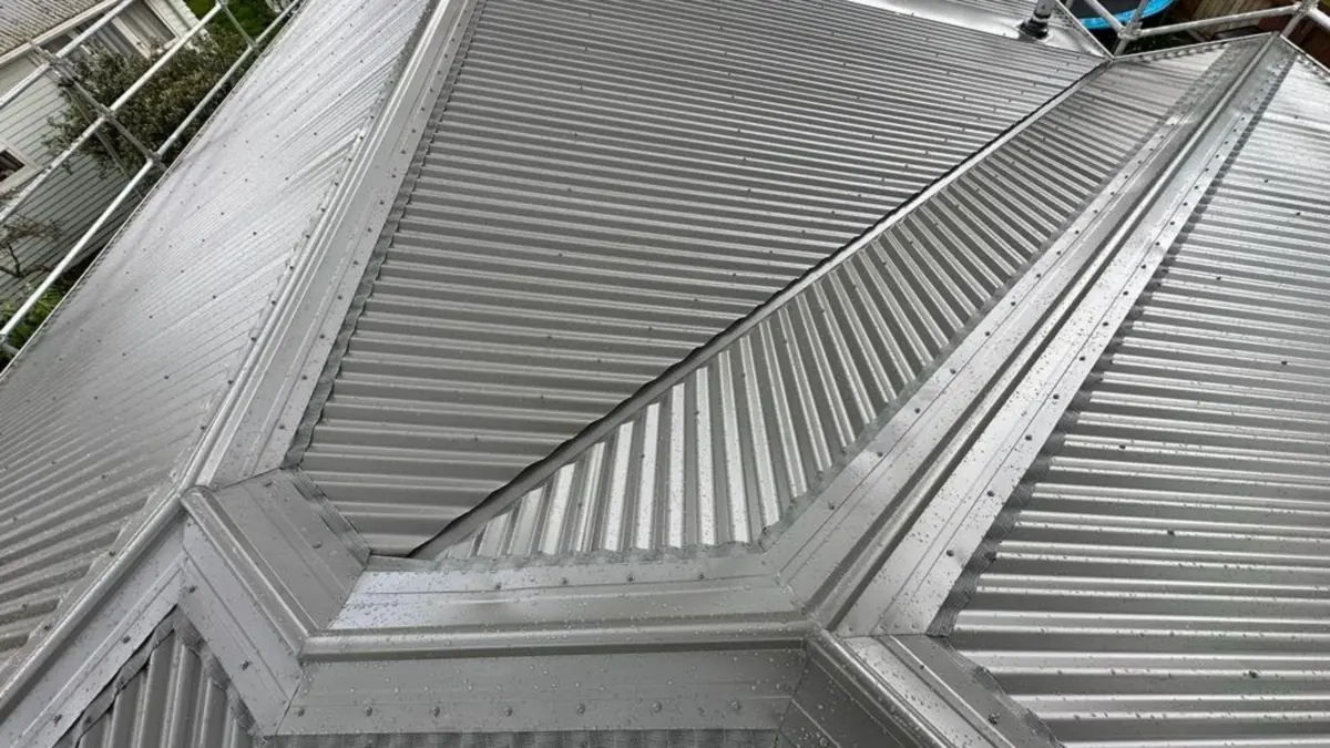 Corrugated steel hip roof showing roof flashing at the ridge and hips