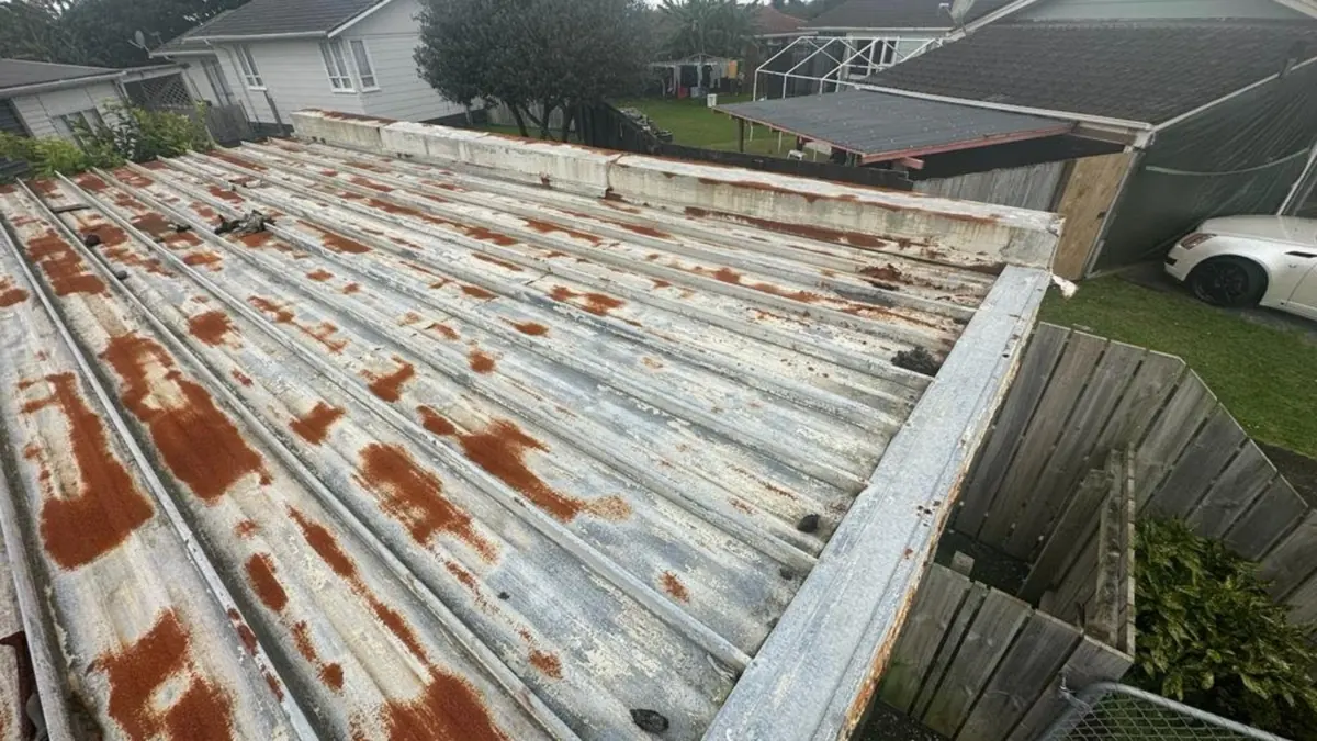 Rusty corrugated iron roof with orange rust patches on an older house, before rusty roof repair
