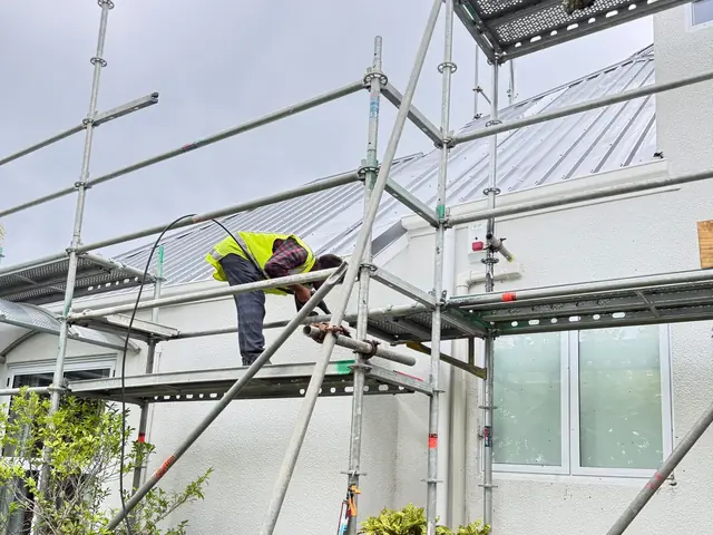 Fascia conversion under way on scaffold, Greenhithe My Homes Construct Ltd tradesperson fixing new fascia from scaffold during a Taylor fascia conversion in Greenhithe, Auckland