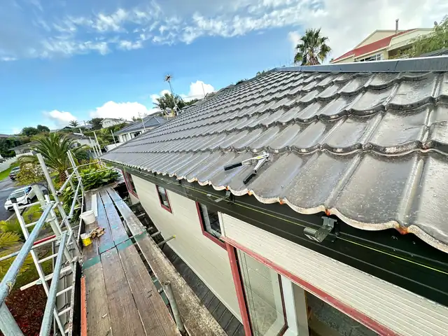 Taylor fascia conversion in progress, West Harbour New metal fascia and gutter brackets being installed along the tile roofline during a Taylor fascia conversion in West Harbour, Auckland