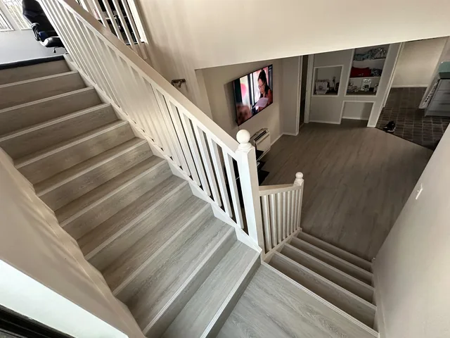Completed laminate timber flooring on stairs and living area in an Auckland home by My Homes Construct Ltd