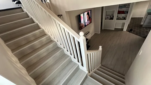 Laminate flooring installed on stairs and living area in an Auckland home by My Homes Construct Ltd