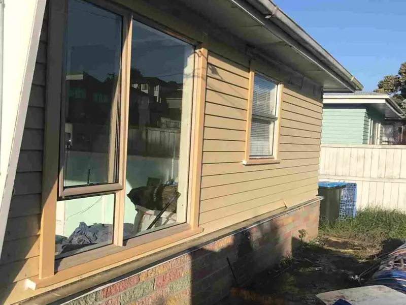New weatherboard cladding and joinery going on during a house renovation in Auckland by My Homes Construct Ltd